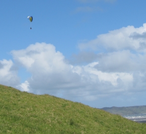 Paraglider soaring high over beautiful west coast